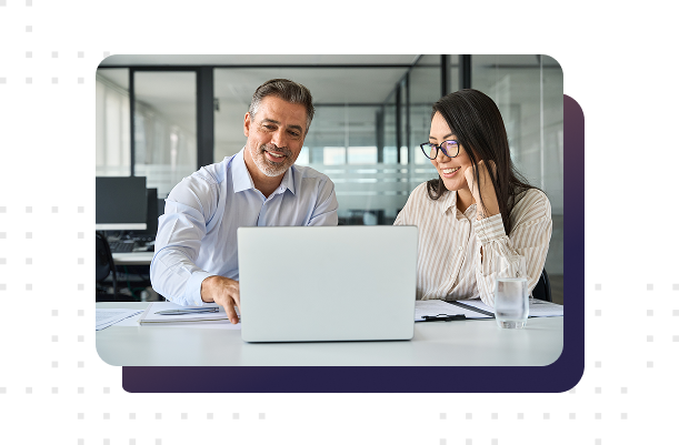 Mature male and female colleagues viewing a laptop together in an office