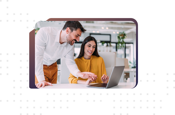 a male and female colleague chat about a recent project while viewing it on their laptop