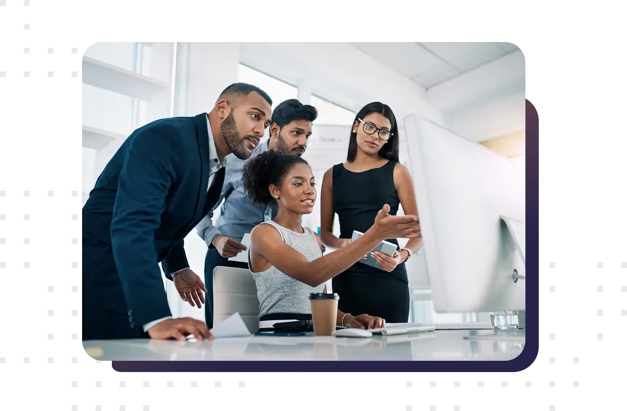 An office compliance team working on a laptop and reviewing regulatory requirements